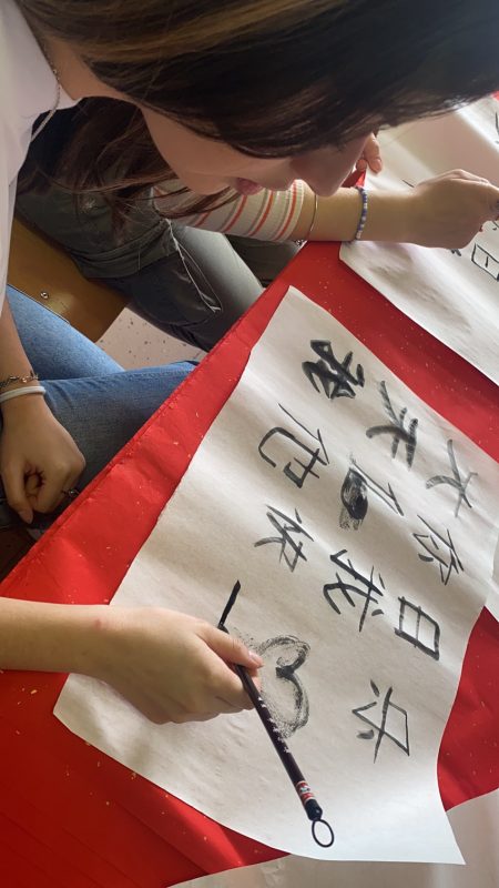 Studenti catturati da vicino mentre praticano la calligrafia cinese in classe.