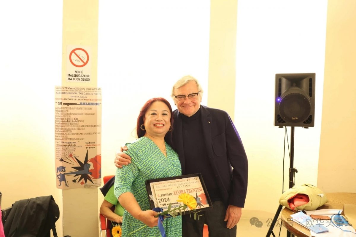 Liu Shan sorride accanto a un uomo premiato alla cerimonia di consegna a Prato