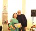 Liu Shan sorride accanto a un uomo premiato alla cerimonia di consegna a Prato