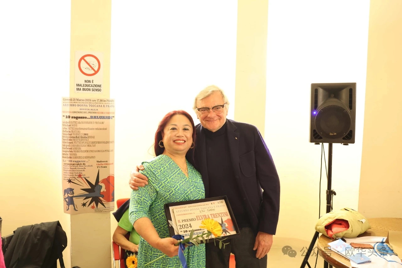 Liu Shan sorride accanto a un uomo premiato alla cerimonia di consegna a Prato