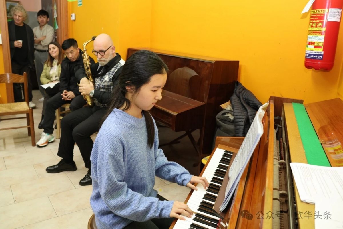 Bambina al pianoforte con saxofonista in una celebrazione culturale.